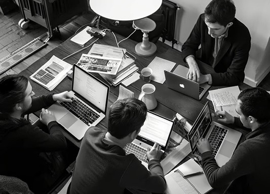 Team working on laptops around a shared table